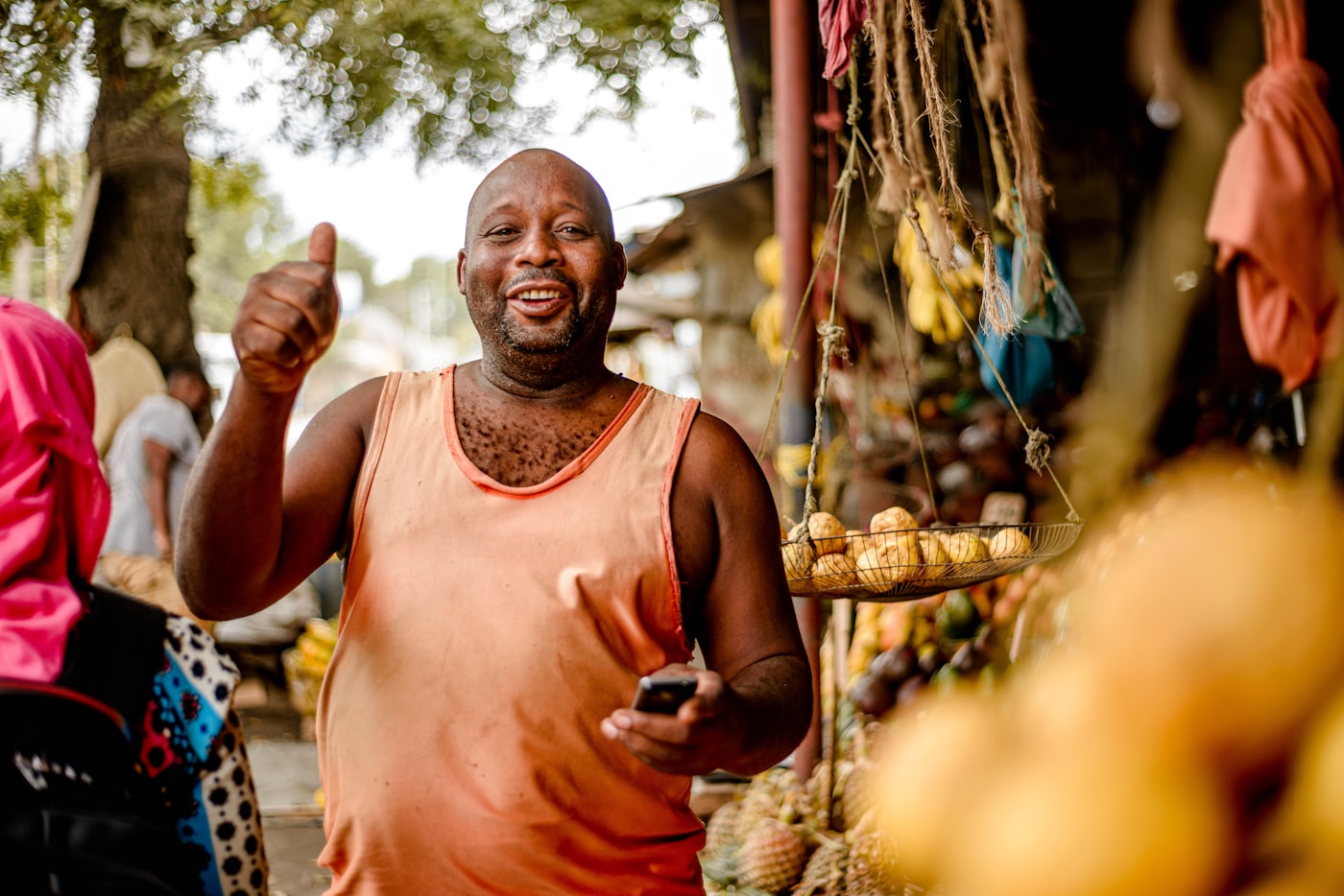 Un commerçant au marché, téléphone à la main